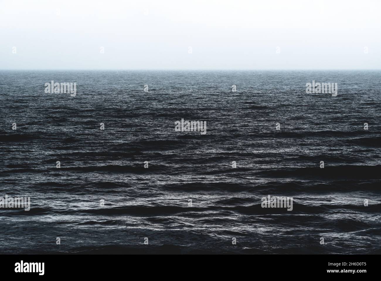 Textur des dunkelblau-silbernen glänzenden Ozeans während des Sturms mit rauen Wellen in Spanien Stockfoto