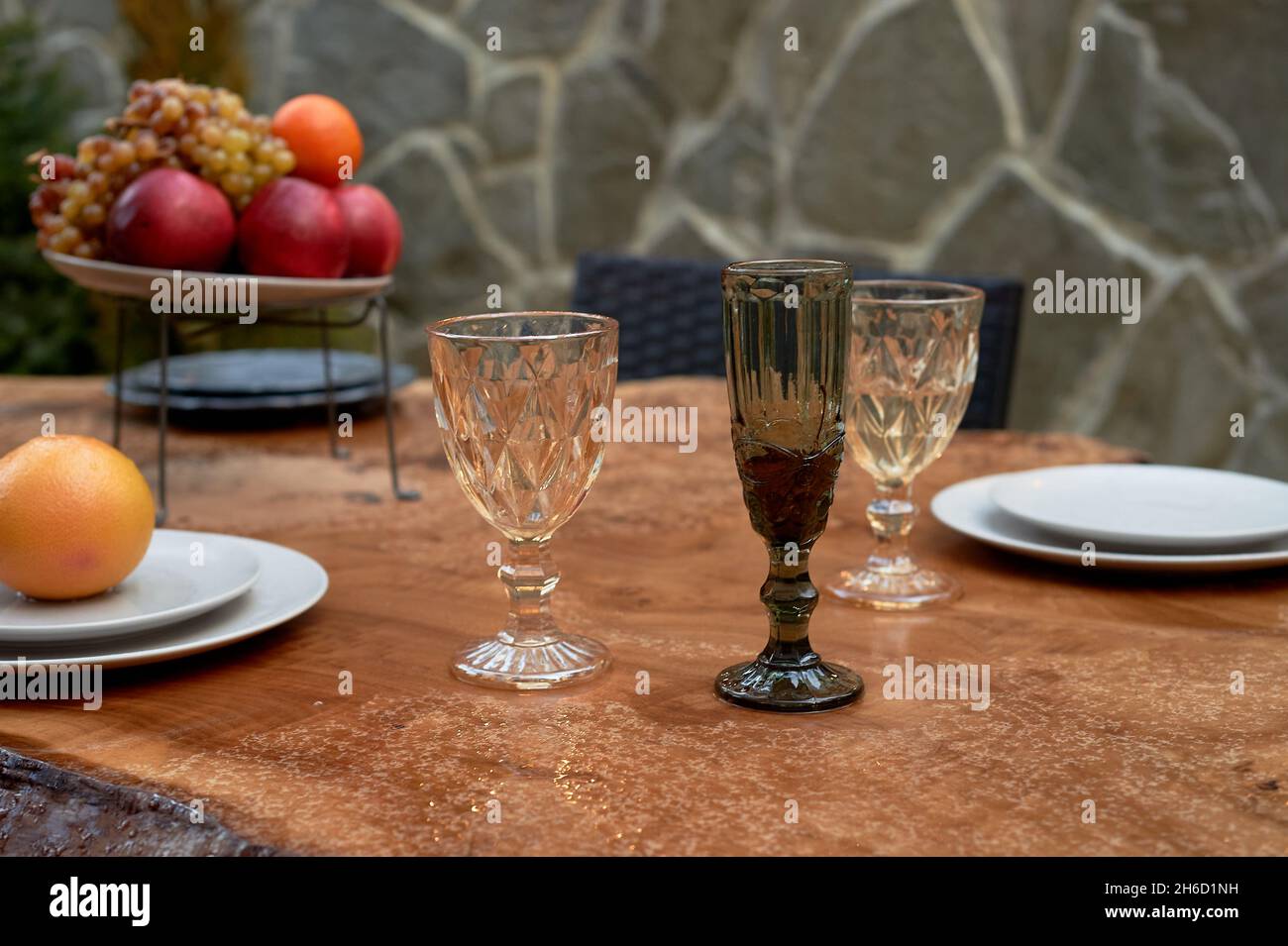 Überdachter Tisch auf der Terrasse. Ein vom Regen nasser Tisch. Die Atmosphäre im Restaurant. Stockfoto