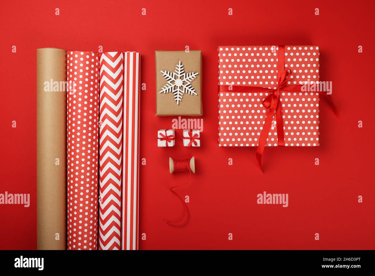Nahaufnahme Verpacken und Verpacken von Weihnachtsgeschenken mit rotem und braunem Papier, Tischansicht, flaches Lay Stockfoto Nahaufnahme Verpacken und Verpacken von Weihnachtsgeschenken mit rotem und braunem Papier, Tischansicht, flaches Lay Stockfoto