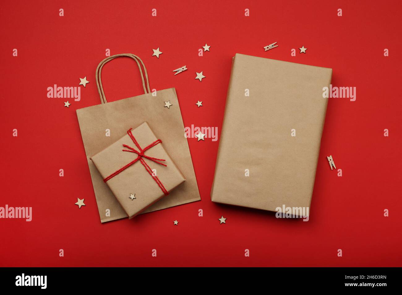 Nahaufnahme Verpacken und Verpacken von Weihnachtsgeschenken mit rotem und braunem Papier, Tischansicht, flaches Lay Stockfoto Nahaufnahme Verpacken und Verpacken von Weihnachtsgeschenken mit rotem und braunem Papier, Tischansicht, flaches Lay Stockfoto
