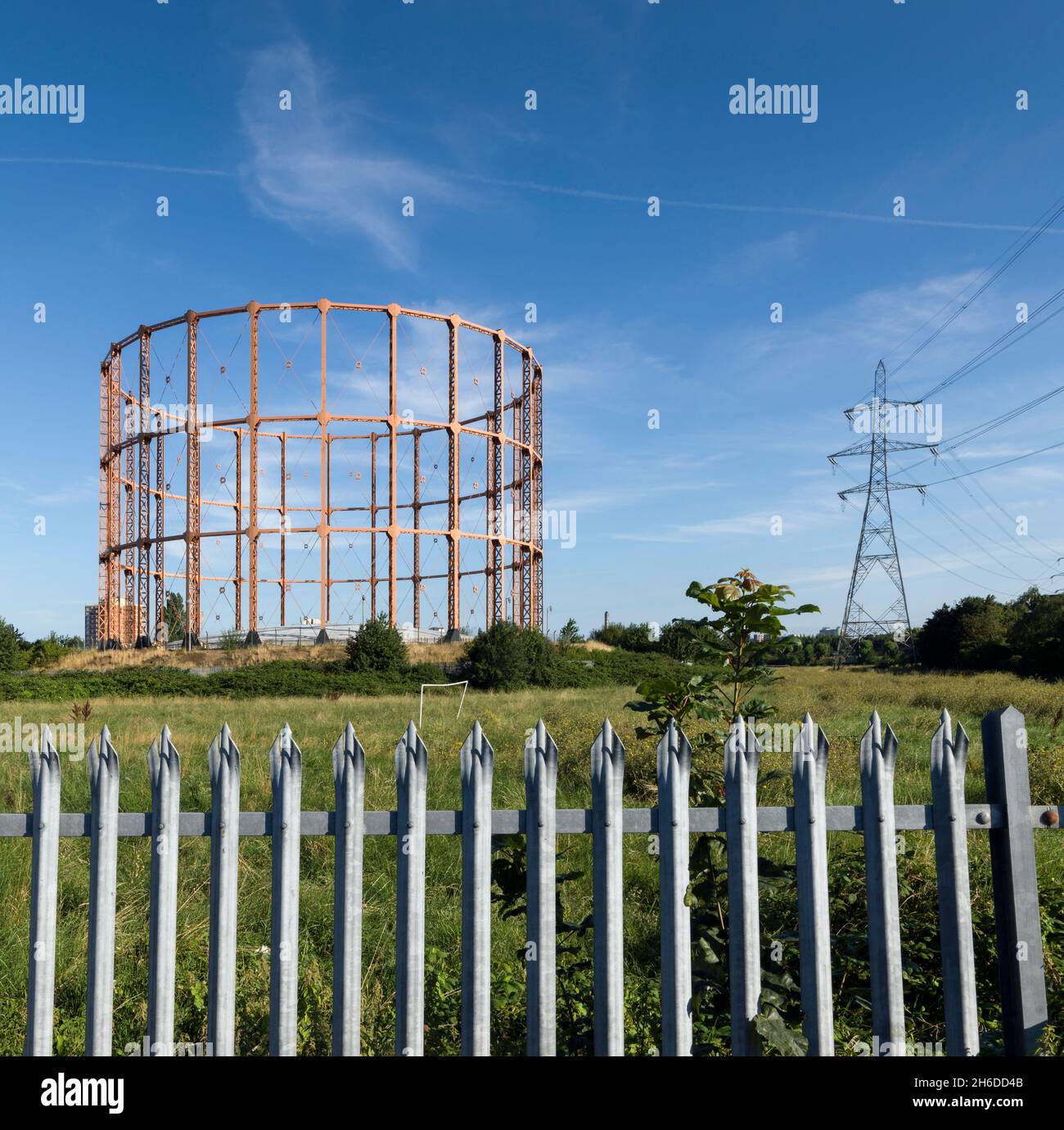 Leigh Road Gashalter, East Ham, Newham, London, 2016. Gesamtansicht des Gashalters von Süden, mit einem metallischen Sicherheitszaun im Vordergrund und einem Strompylon im Hintergrund. Stockfoto