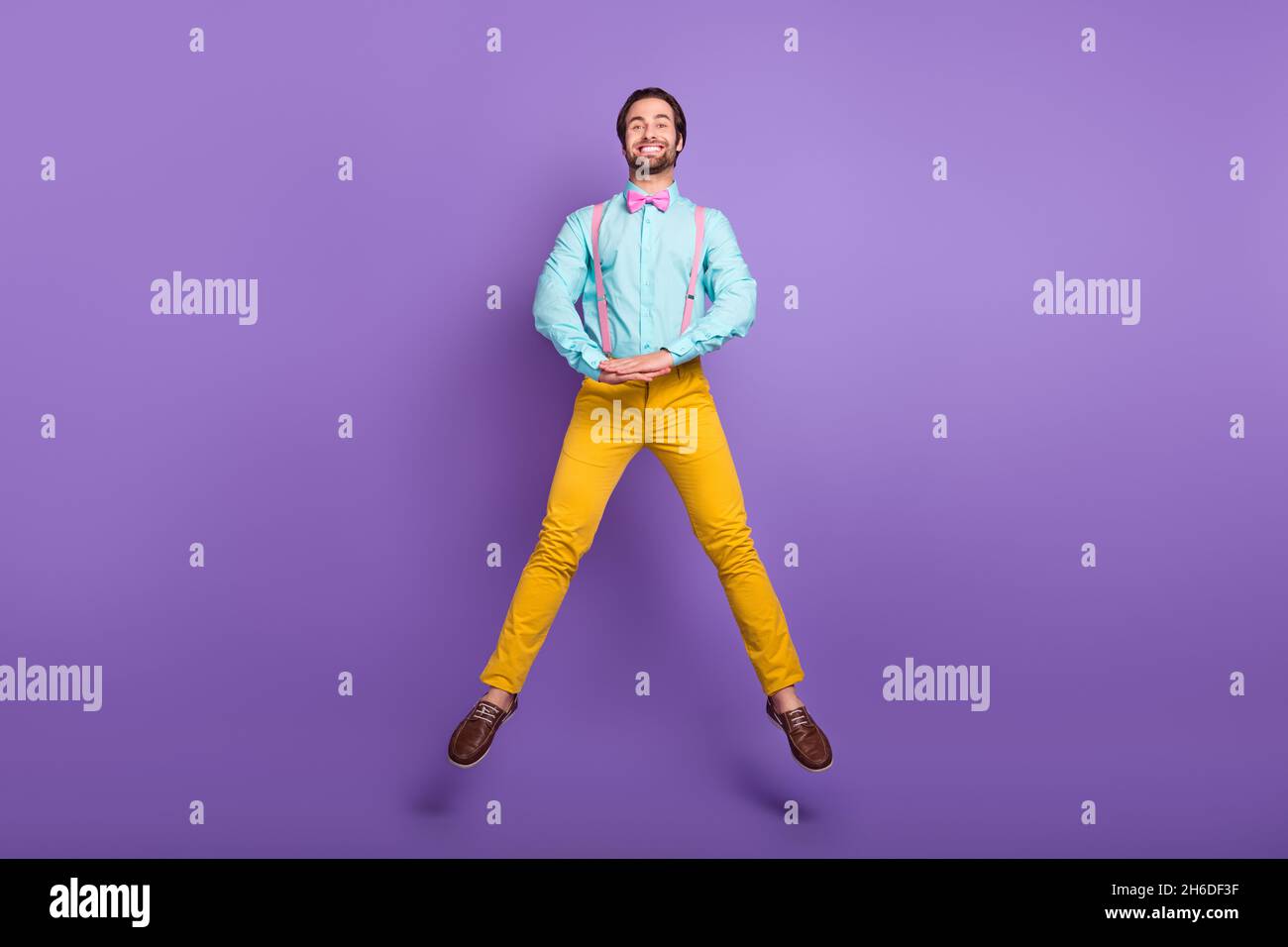 In voller Länge Foto von schön Millennial Kerl springen tragen Krawatte Hosenträger Hemd Hosen Schuhe auf lila Hintergrund isoliert Stockfoto
