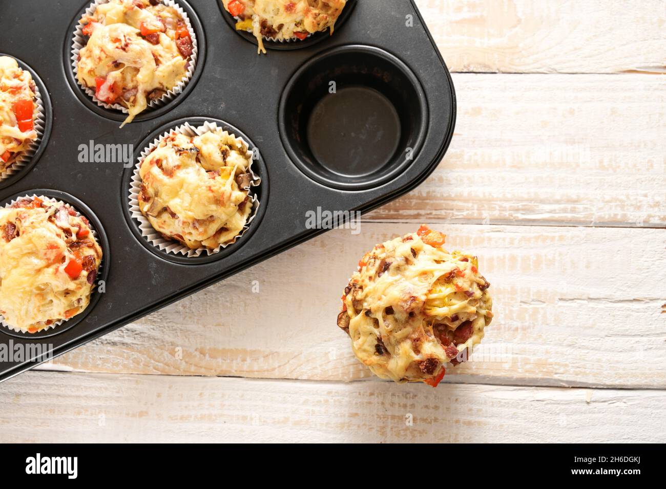 Hausgemachte Fingerfood als Party-Snack, Pizza-Muffins in einem Tablett auf einem Holztisch gebacken, Blick von oben, Kopierraum, ausgewählter Fokus, schmal d Stockfoto