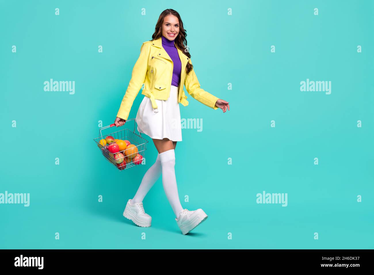 Ganzkörper-Profil Seitenfoto der jungen Frau Schritt Shop Bio-Markt isoliert über türkisfarbenen Hintergrund Stockfoto
