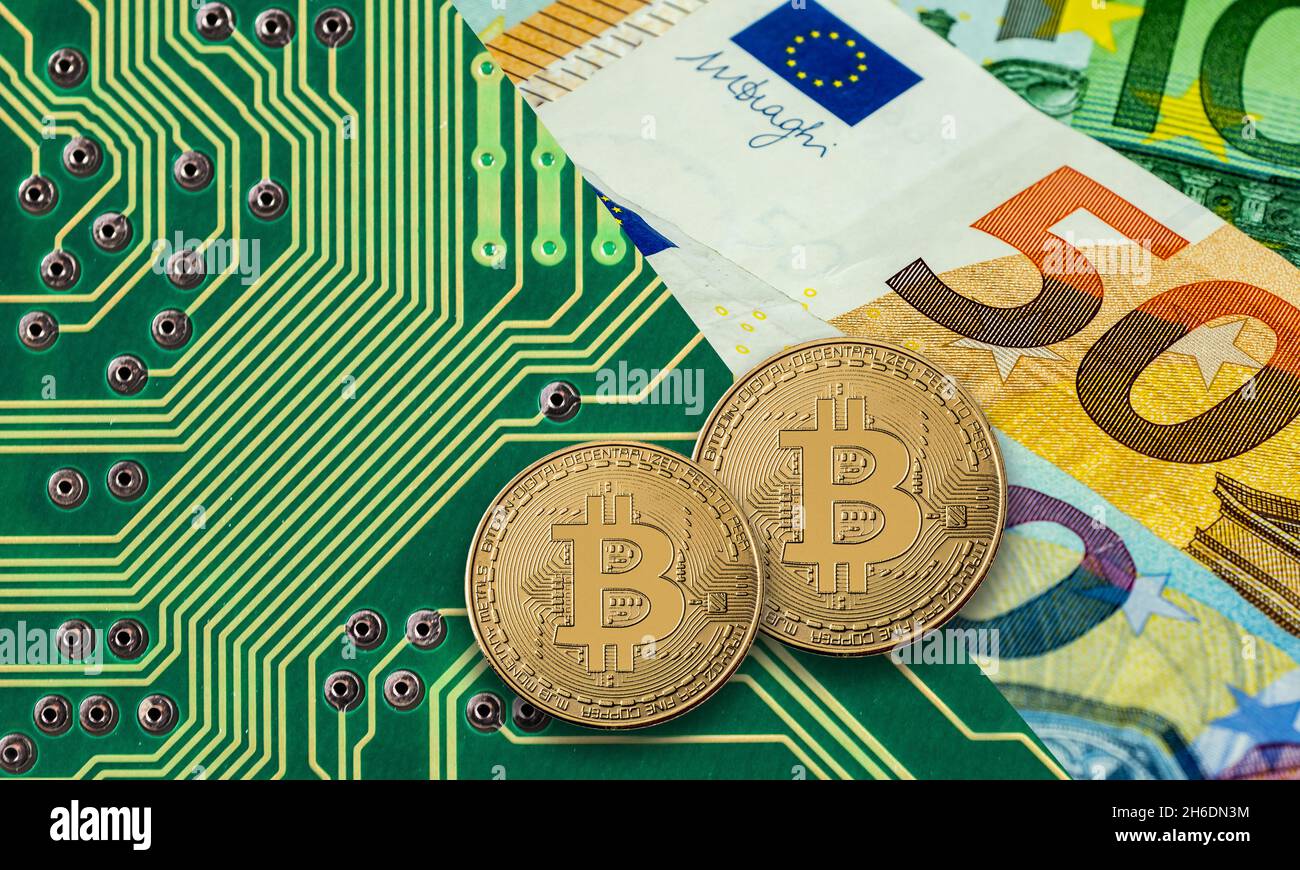 Bitcoin Goldmünze auf grüner Computerplatine mit Euro Stockfoto