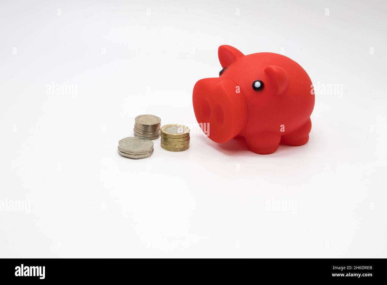 Geld sparen für einen regnerischen Tag. Sparschwein und Bargeld auf weißem Hintergrund Stockfoto