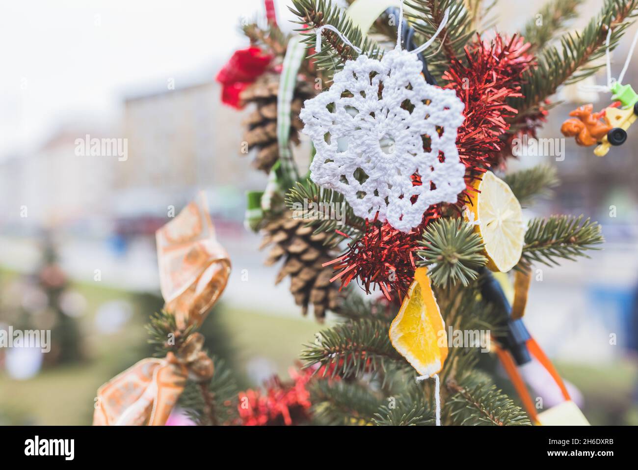 DIY weiße Deckchen auf Weihnachtsbaum. Handgefertigte Weihnachtsdekoration Ideen für Kinder. Umwelt, Wiederverwendung, Recycling, Upcycling und Zero Waste Konzept. Selektiver Fokus, Kopierbereich Stockfoto