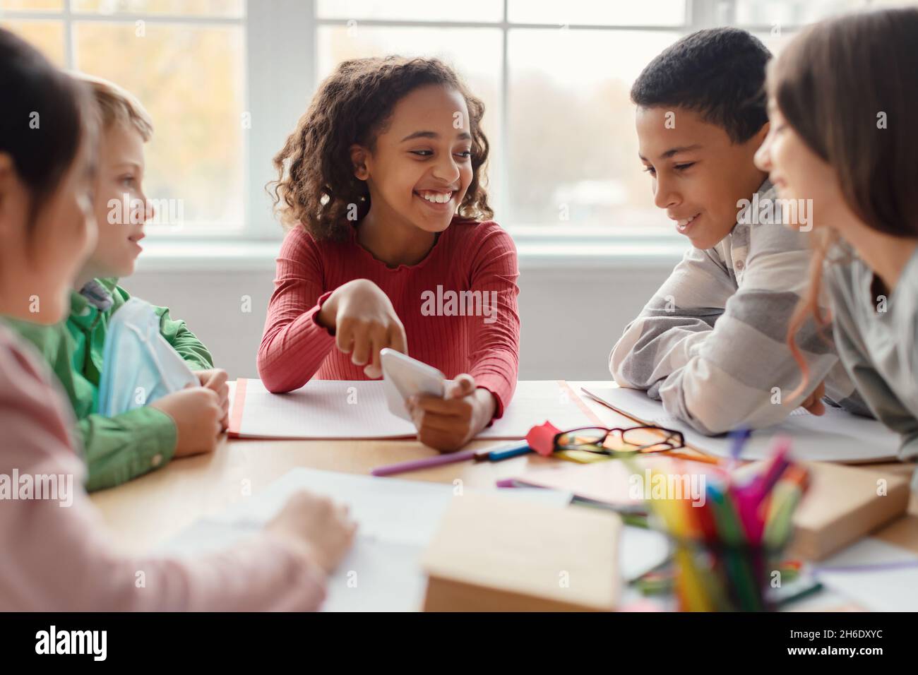 Schulkinder Haben Spaß Mit Dem Smartphone Während Der Pause Im Klassenzimmer Stockfoto
