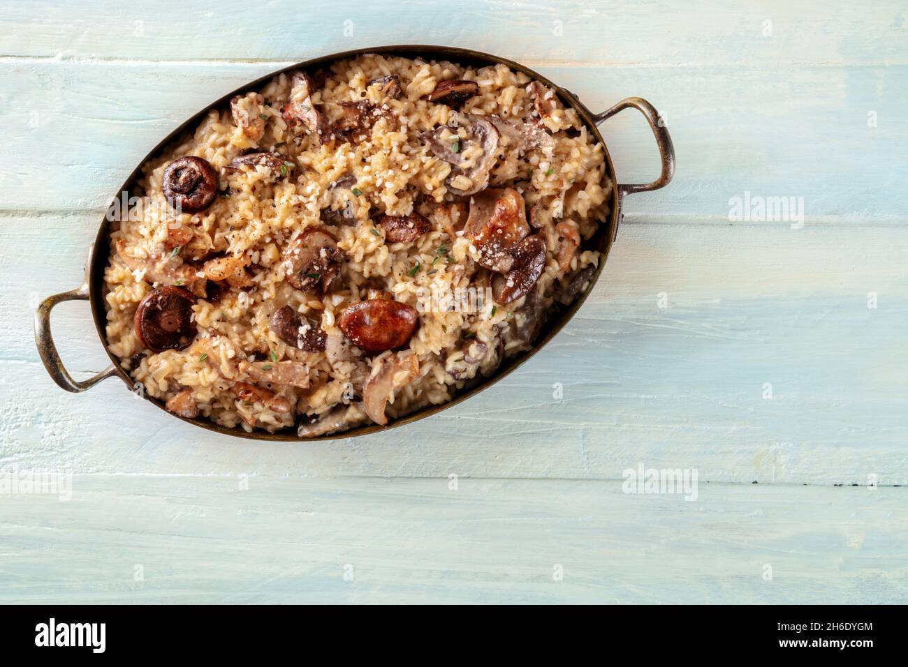 Risotto ai funghi, Pilzreis, von oben auf einem rustikalen Holzhintergrund mit einem Platz für Text geschossen Stockfoto