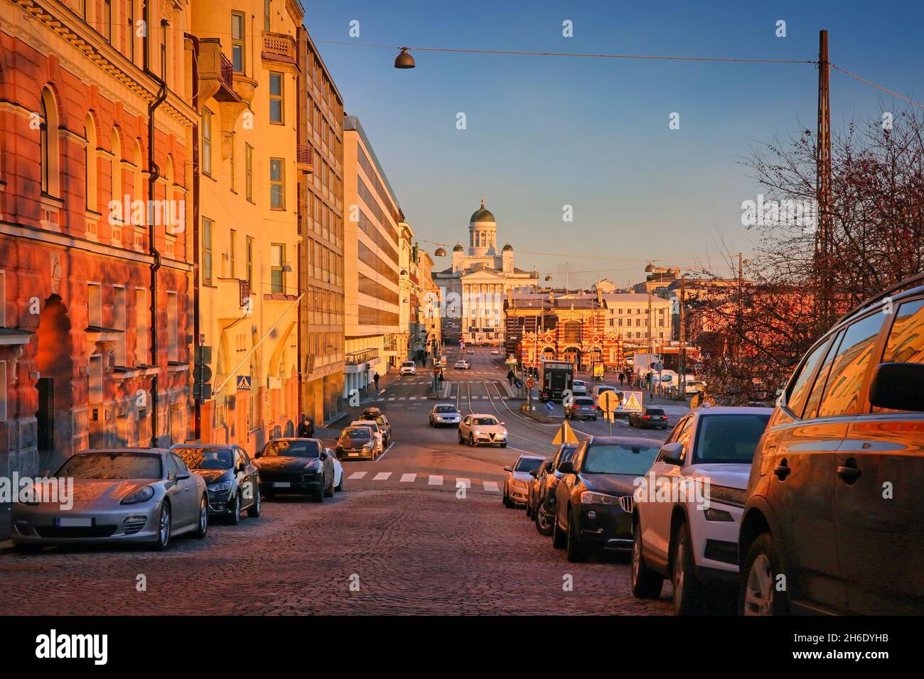 Autos und langsamer Verkehr in Eteläranta, Helsinki, Finnland in der goldenen Stunde eines sonnigen Novembermorgens. Die Kathedrale von Helsinki im Hintergrund. 2021. Stockfoto