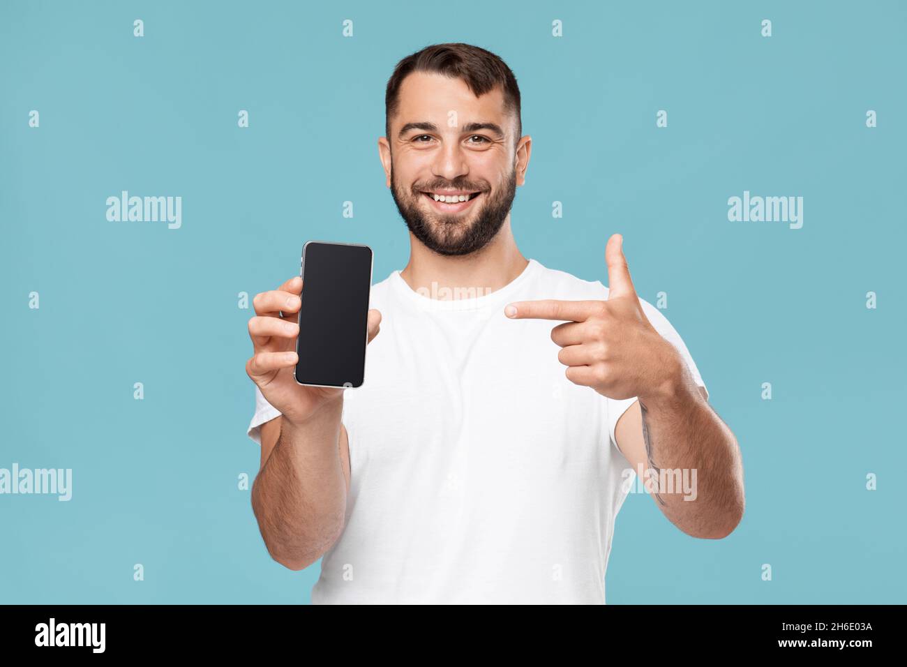 Freundlich froh reifen kaukasischen männlichen zeigen Finger zum Smartphone mit leerem Bildschirm zur Kamera Stockfoto