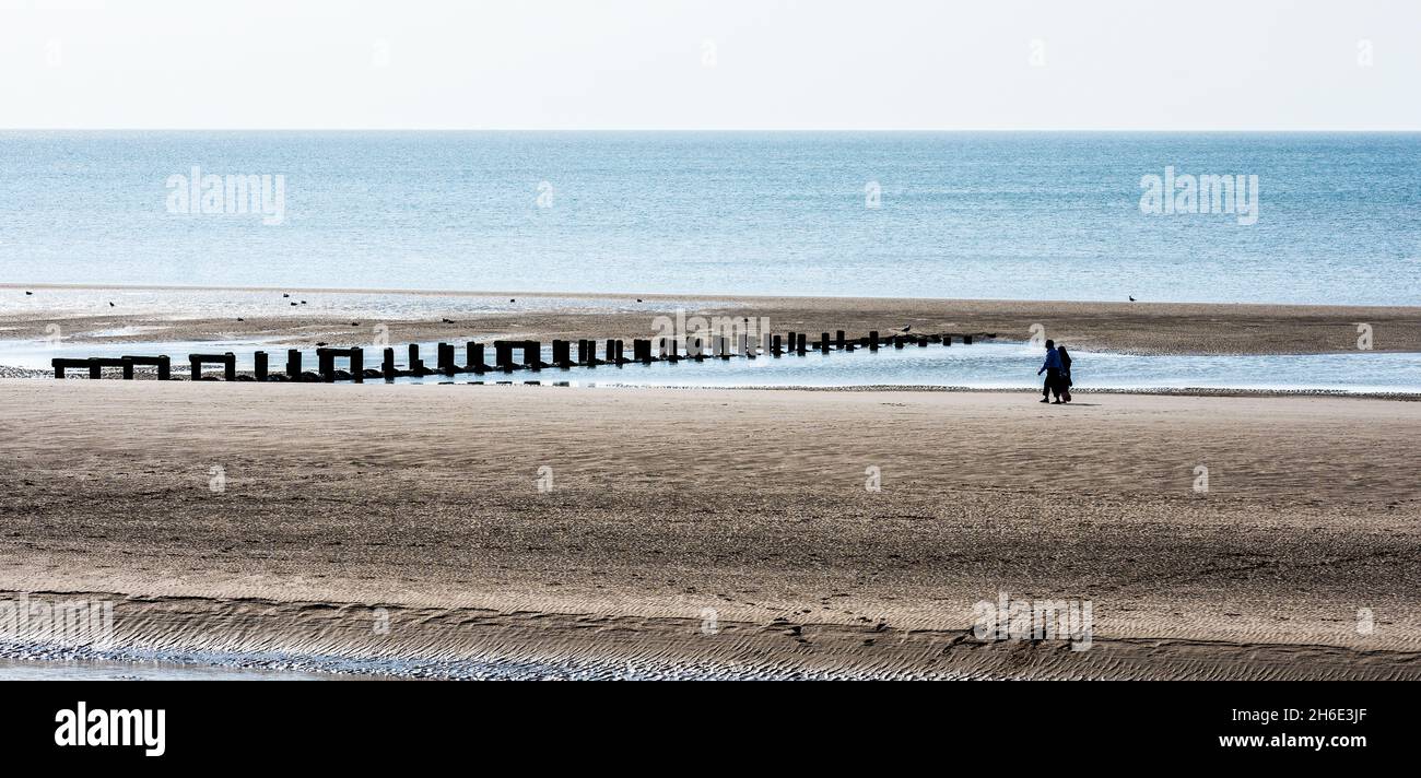 Ein Paar macht einen gemütlichen Spaziergang am Blackpool Beach, Lancashire, Großbritannien. Stockfoto