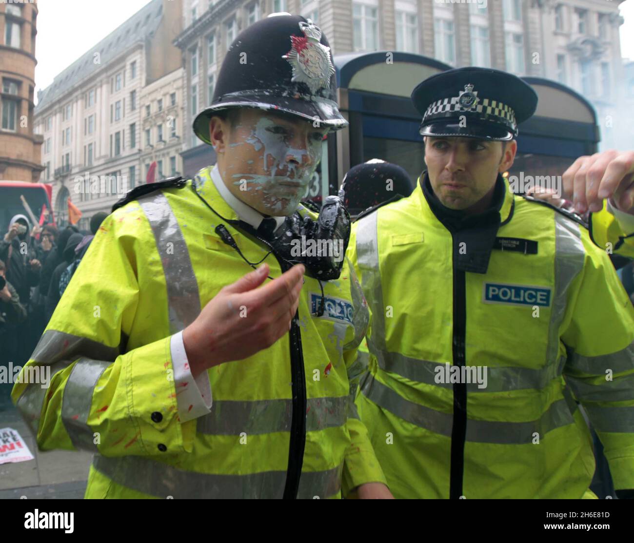 Während der TUC-Anti-Cuts-Demo im Zentrum von London wird ein Polizeibeamter von einer Farbbombe in der Oxford Street getroffen Stockfoto