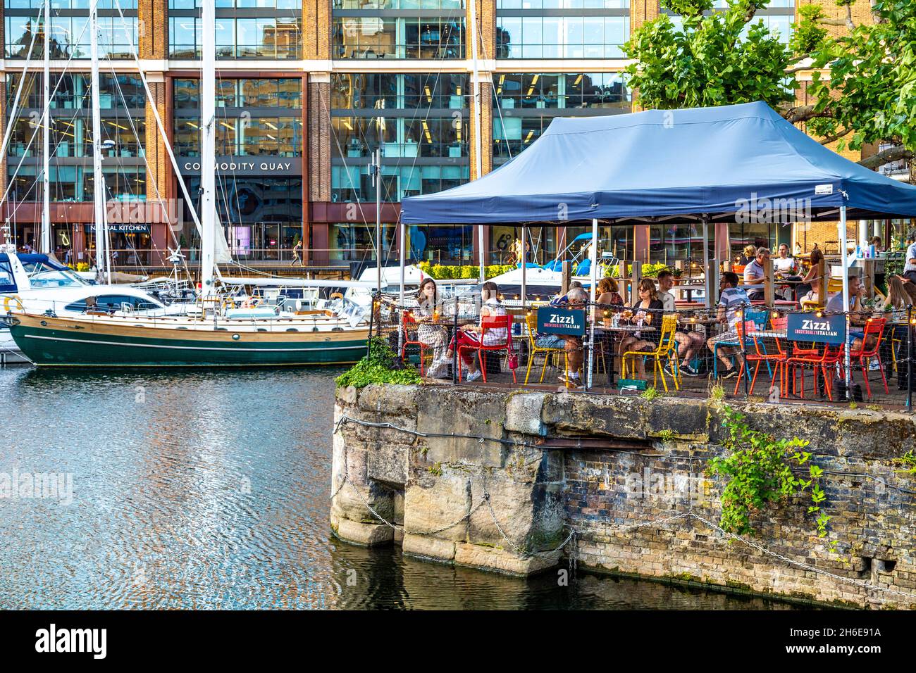 Menschen essen im Zizzi Restaurant mit Blick auf die St Katharine Docks, London, Großbritannien Stockfoto