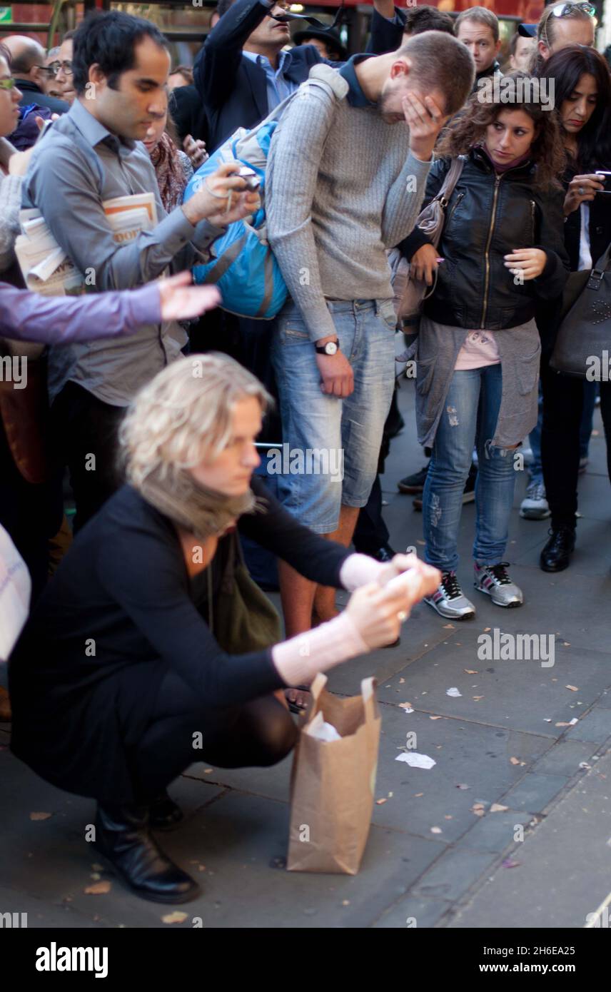 Steve Jobs stirbt – Ein Mann weint heute Abend vor dem Apple-Store in der Londoner Regent Street, während die Massen die Tribute ansehen, die für den Mitbegründer von Apple, Steve Jobs, hinterlassen wurden. Stockfoto