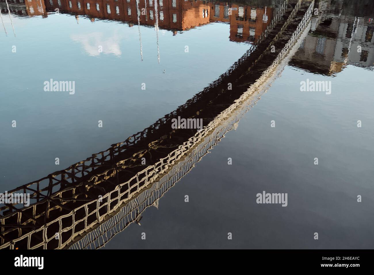 Die Ha'Penny Bridge spiegelt sich im Fluss Liffey in Dublin, Irland, wider. Stockfoto