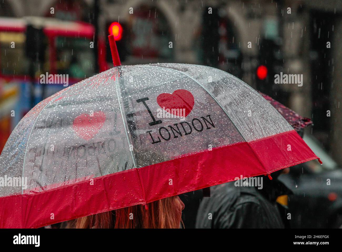 In Piccadilly, im Zentrum von London, decken sich die Bürger vor dem Regen. Stockfoto