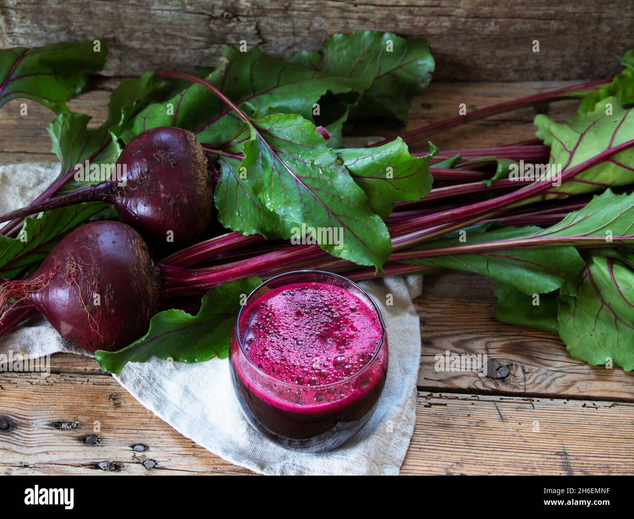 Frischer Smoothie-gepresster Rote-Bete-Saft in einem Glas auf einer Holzoberfläche Stockfoto