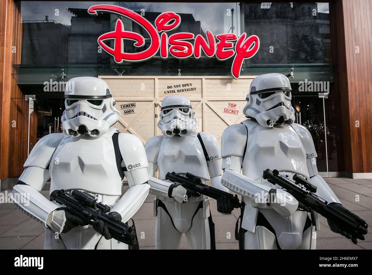 Stormtroopers und R2-D2 schlossen sich einem jungen Star Wars-Fan an, der als Prinzessin Leia Daisy im Alter von 8 Jahren im Disney Store in der Oxford Street gekleidet war, um den finalen Countdown bis Mitternacht zu beginnen, als die mit Spannung erwartete Star Wars: The Force Awakens-Produktlinie am 4. September auf den Markt kommt. Stockfoto