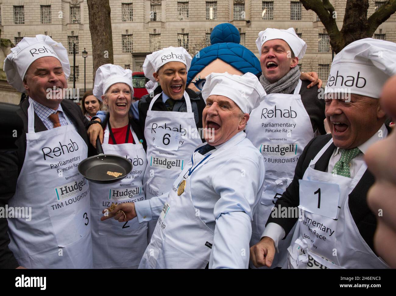 Das Parliamentary Pancake Race 2016 fand heute Morgen in den Victoria Tower Gardens in der Nähe der Houses of Parliament statt. Stockfoto