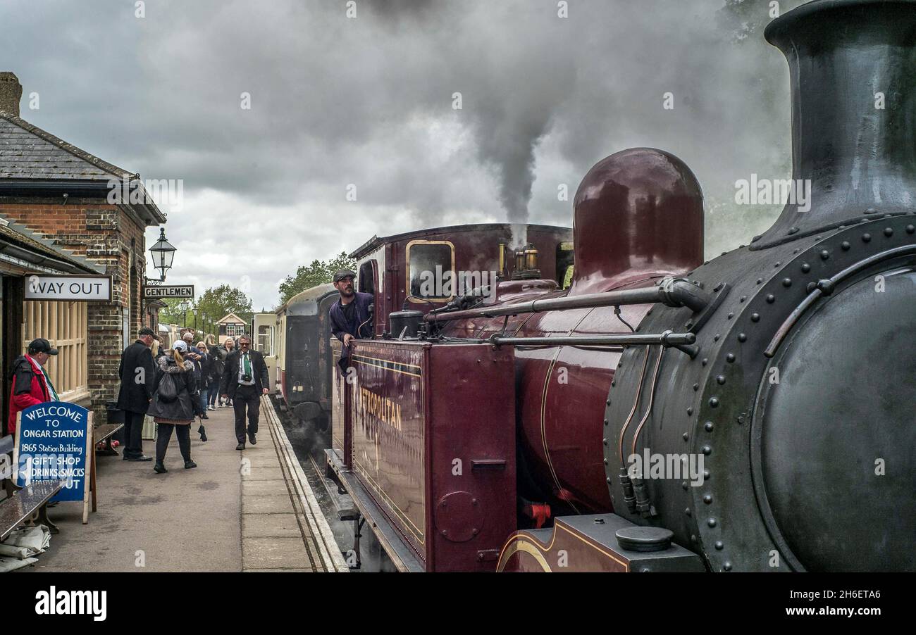 Dampfzug-Enthusiasten in Essex genießen die Epping Ongar-Eisenbahn an einem feuchten Feiertag am Montag. Stockfoto