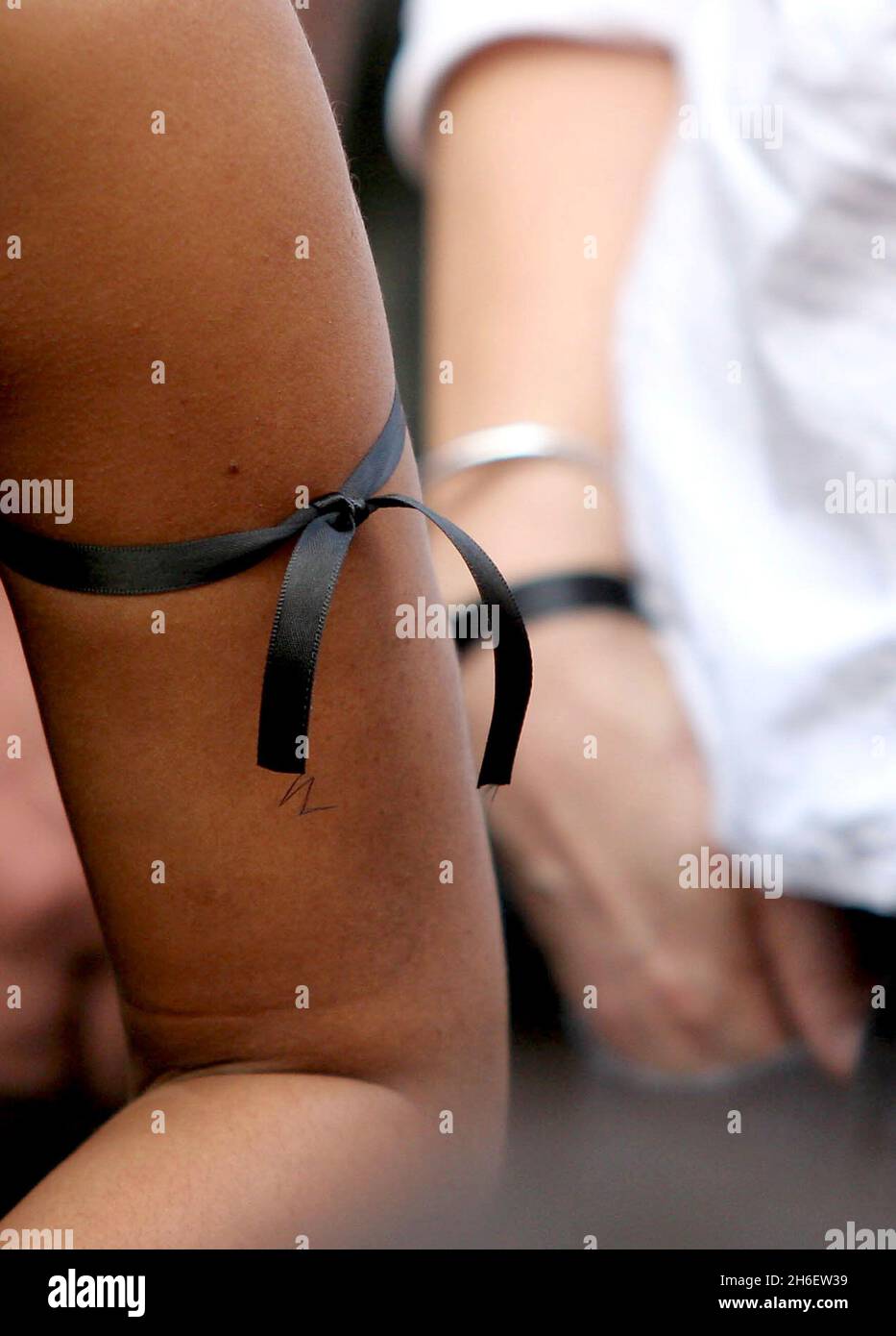 Mitglieder der Öffentlichkeit binden schwarze Bänder an ihre Arme und Hände, um Frieden und Trauer während eines 2-minütigen Schweigens für die Toten und Verletzten bei den Londoner Bombenanschlägen am donnerstag in den Friedengärten des Friends Meeting House in London zu symbolisieren. 49 Menschen starben und 700 Menschen wurden verletzt, als am 07/07/05 vier Bombenangriffe durch das Londoner Verkehrssystem gerissen wurden. Jeff Moore/allactiondigital.com Stockfoto