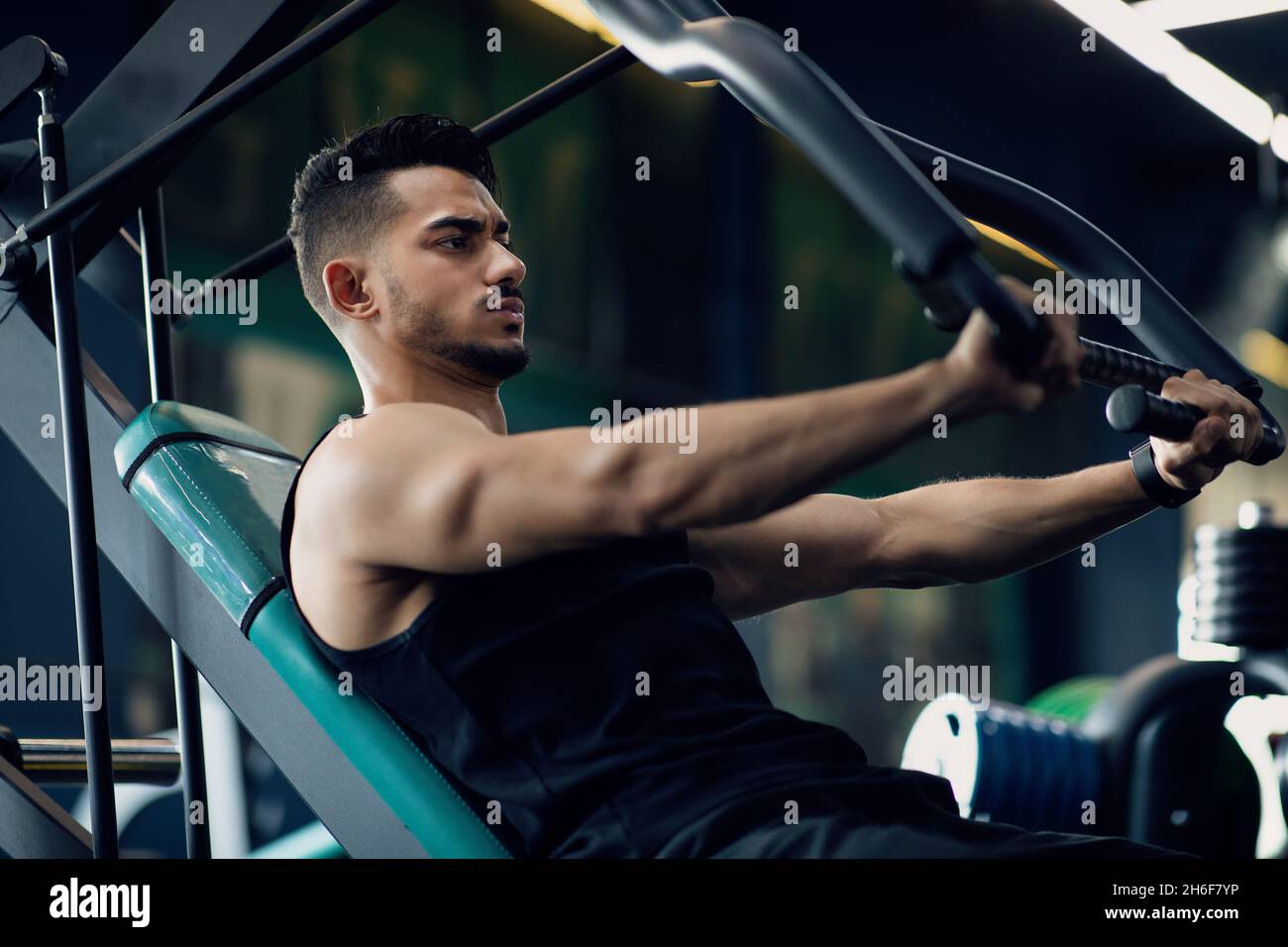 Motivierter Muskulöser Arabischer Mann Beim Training Auf Sportmaschine Im Fitnessstudio Stockfoto