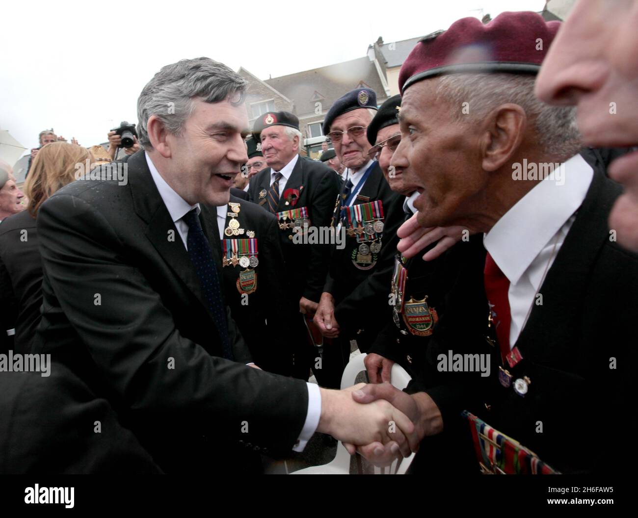 Der britische Premierminister Gordon Brown und seine Frau Sarah begrüßen die Kriegsveteranen der Normandie in der französischen Stadt Arromanche, in der Nähe des Ortes, an dem vor 65 Jahren britische Truppen an Land stürmten, am 65. Jahrestag des D-Day. Stockfoto