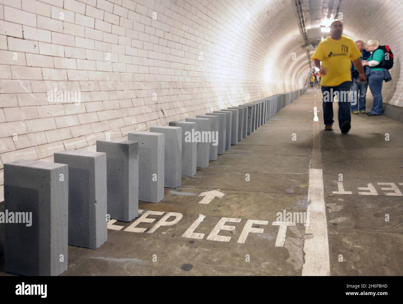 Dominosteine im Fußtunnel unter der themse von Island Gardens nach Greenwich als Teil einer 20 Meilen langen riesigen Domino-Rallye aus Windblöcken, die sich heute durch die fünf Bezirke der Olympischen Spiele 2012 in London erstreckte. 50,000 BREEZE-Blöcke wurden wie eine Reihe von Dominosteinen aufgestellt, wobei das Umstürzen der Blöcke am Nachmittag begann und 6 Stunden dauerte, bis es in einem großen Finale in der Dämmerung abgeschlossen wurde. Die Strecke führt durch Parks, Schulplätze, Wasserwege, Brücken und Unterführungen. Stockfoto