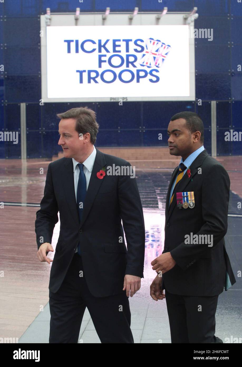 Der konservative Führer David Cameron startet sein Ticket for Trupps-Programm, das die Veranstalter von Musikkonzerten und Sportveranstaltungen dazu anregt, Soldaten Freikarten zu geben. Bild zeigt: David Cameron mit dem Soldaten Johnson Beharry Stockfoto