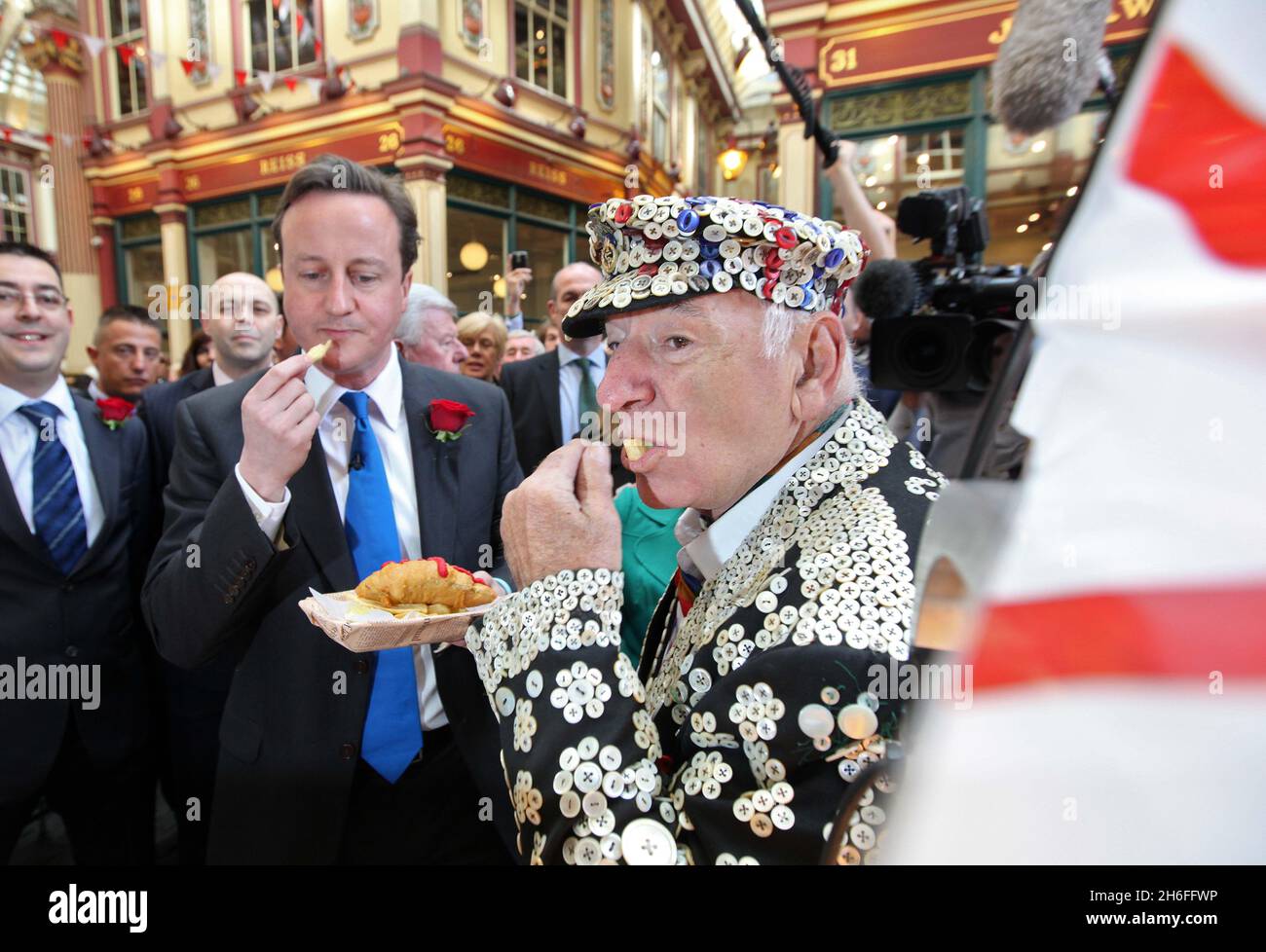 Der konservative Parteichef David Cameron genoss an diesem Nachmittag Fisch und Chips mit einem Perlkönig bei der St. George's Day-Feier im Leadenhall Market, London Stockfoto