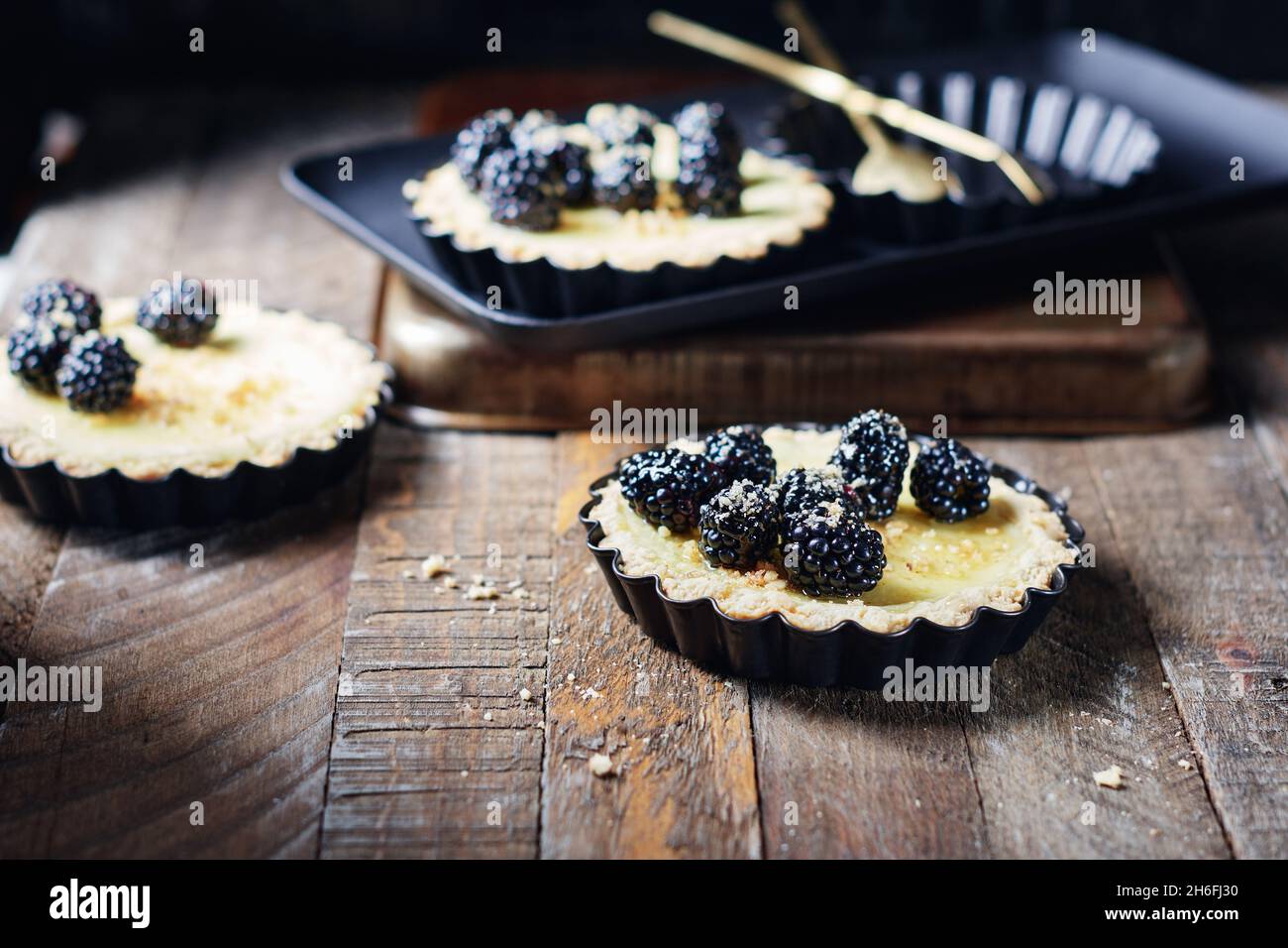 Frisch gebackene Brombeeren- und Vanillepudding-Torten. Stockfoto