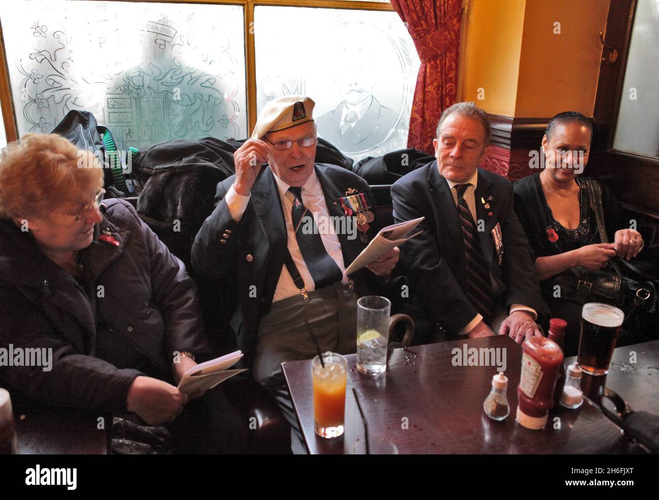 Veteranen des Zweiten Weltkriegs und ihre Familien genießen ein Pint und ein Lied im Sherlock Holmes Pub in Westminster, nachdem sie heute am Remembrance Sunday teilgenommen haben. Stockfoto