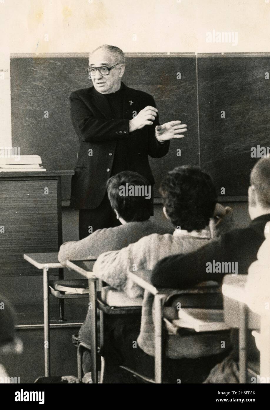 Ein katholischer Priester, der in der Schule im Klassenzimmer unterrichtet, Italien in den 1970er Jahren Stockfoto
