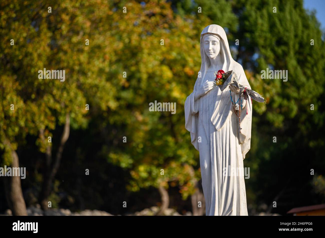 Statue der seligen Jungfrau Maria auf dem Berg Podbrdo, dem Erscheinungsberg mit Blick auf das Dorf Medjugorje in Bosnien und Herzegowina. Stockfoto
