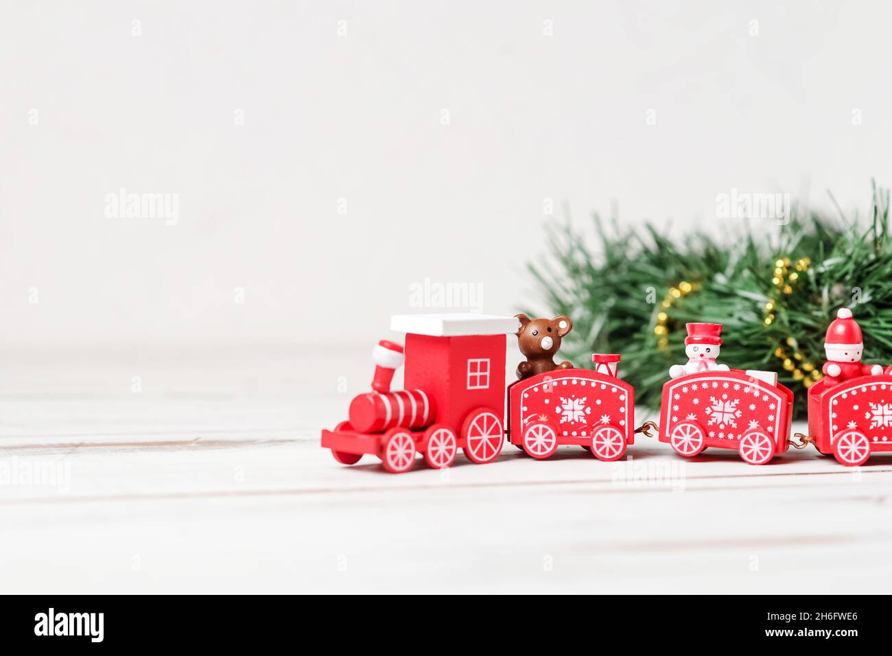 Das Konzept des kommenden neuen Jahres, Weihnachten. Der rote Neujahrszug mit einem grünen Ast auf weißem Hintergrund. Stockfoto