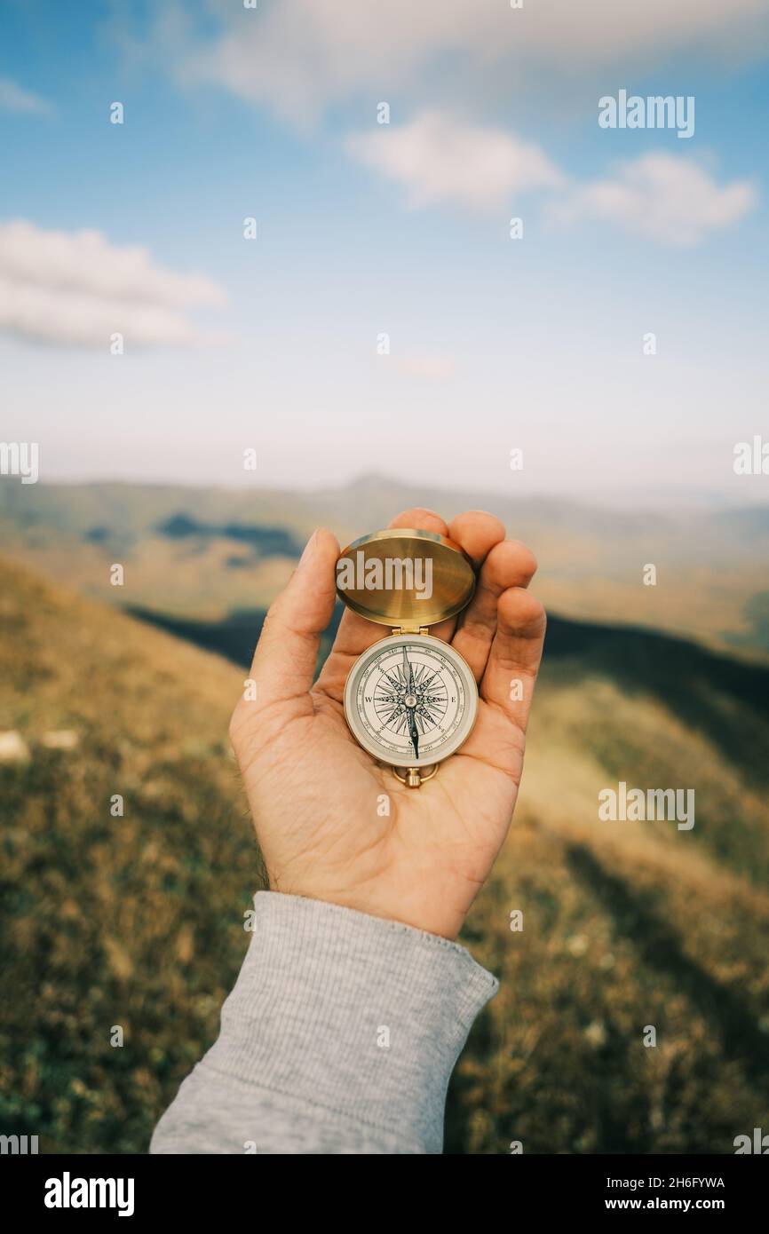 Kompass in der Hand in der Hintergrund Berglandschaft. Stockfoto