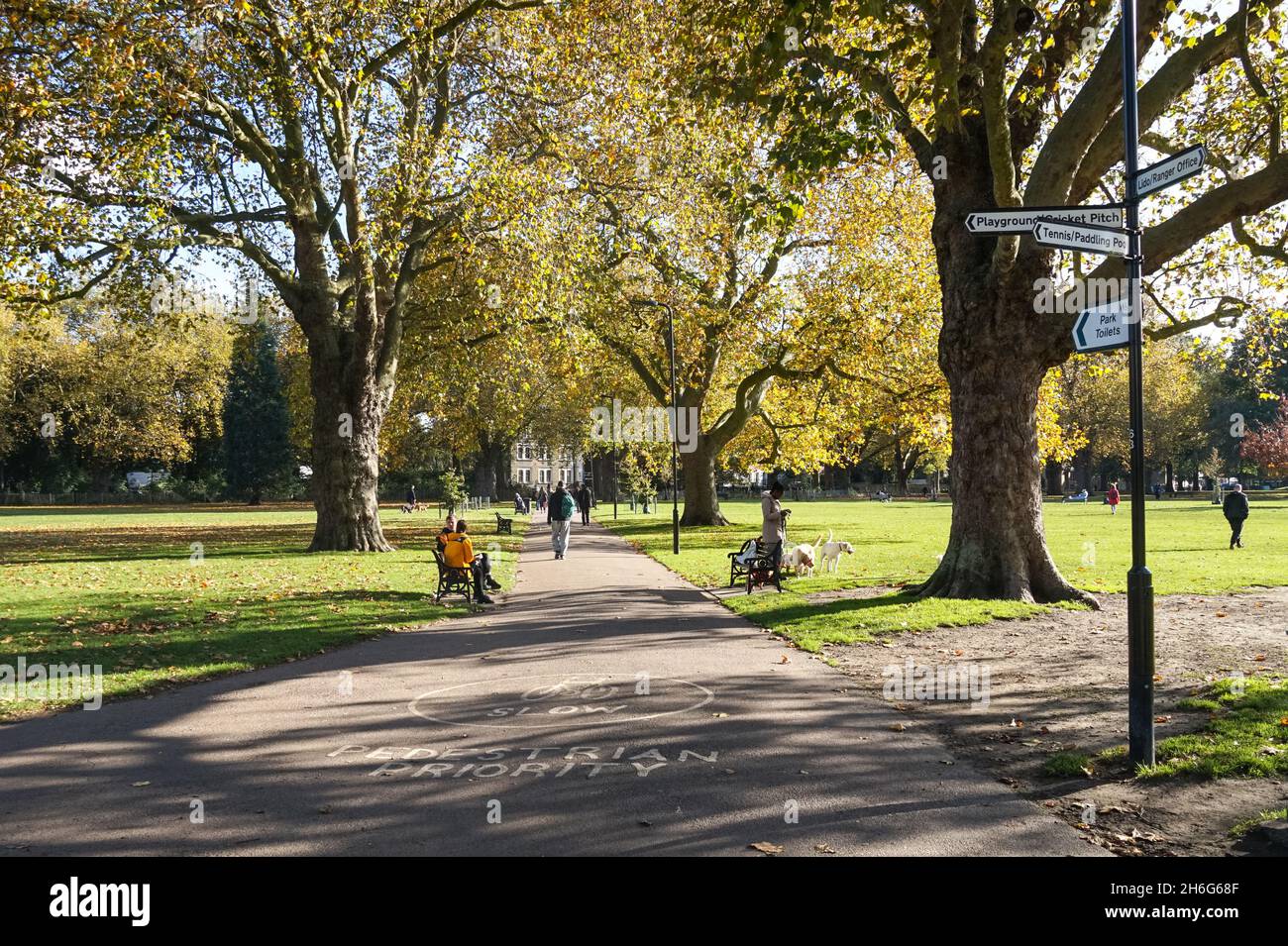 Menschen genießen sonnigen Herbsttag in London Fields Park in Hackney, London England Vereinigtes Königreich Großbritannien Stockfoto