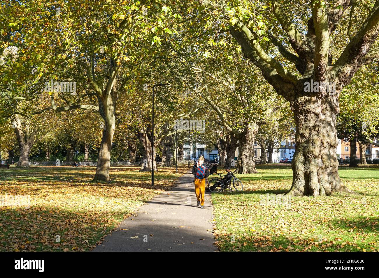 Menschen genießen sonnigen Herbsttag in London Fields Park in Hackney, London England Vereinigtes Königreich Großbritannien Stockfoto