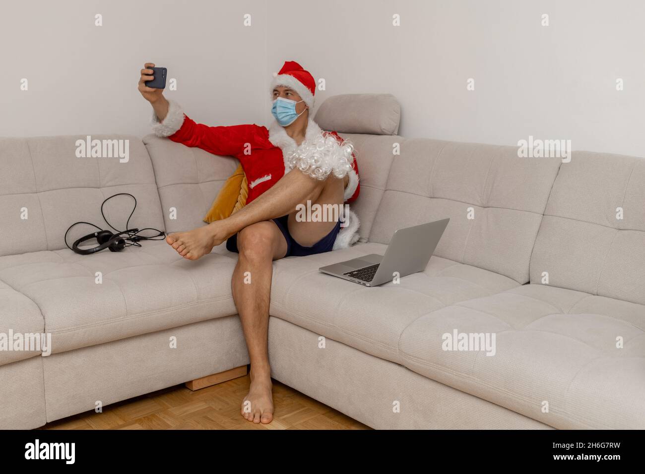 Gekleidet als Weihnachtsmann mit Laptop ohne Hose Stockfoto