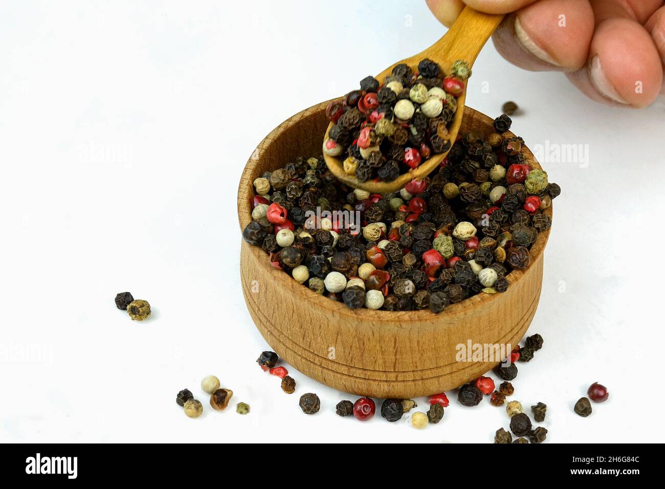 Koch nimmt trockene Gewürze Mischung aus verschiedenen farbigen Paprika Erbsen aus Holz Gewürzglas. Selektiver Fokus. Konzentrieren Sie sich auf Gewürze im Glas. Nahaufnahme. Stockfoto