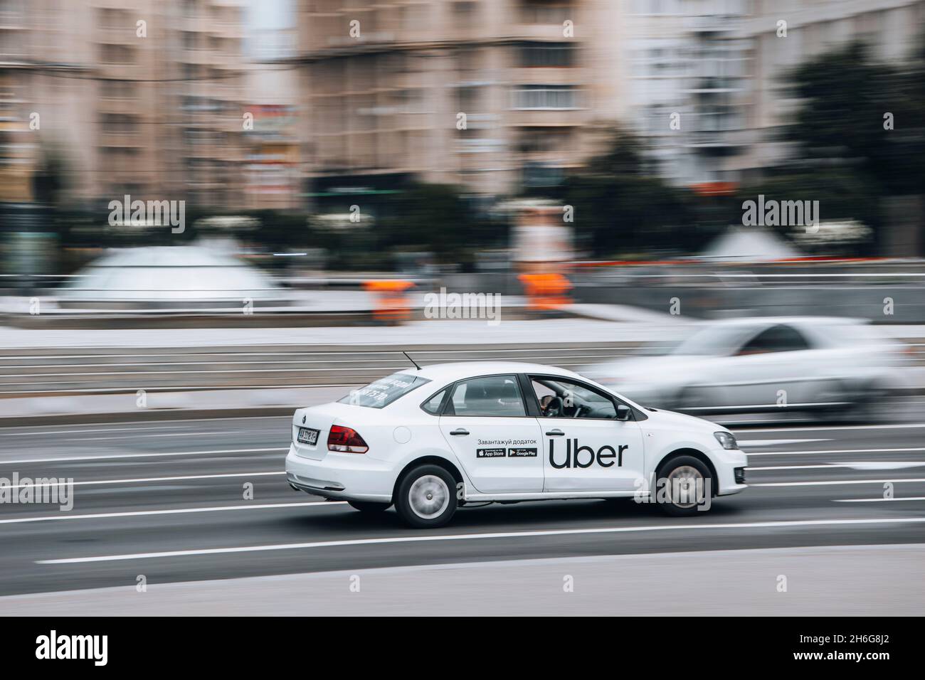 Ukraine, Kiew - 2. Juni 2021: Weißes Volkswagen Polo Taxi Uber Auto bewegt sich auf der Straße. Redaktionell Stockfoto