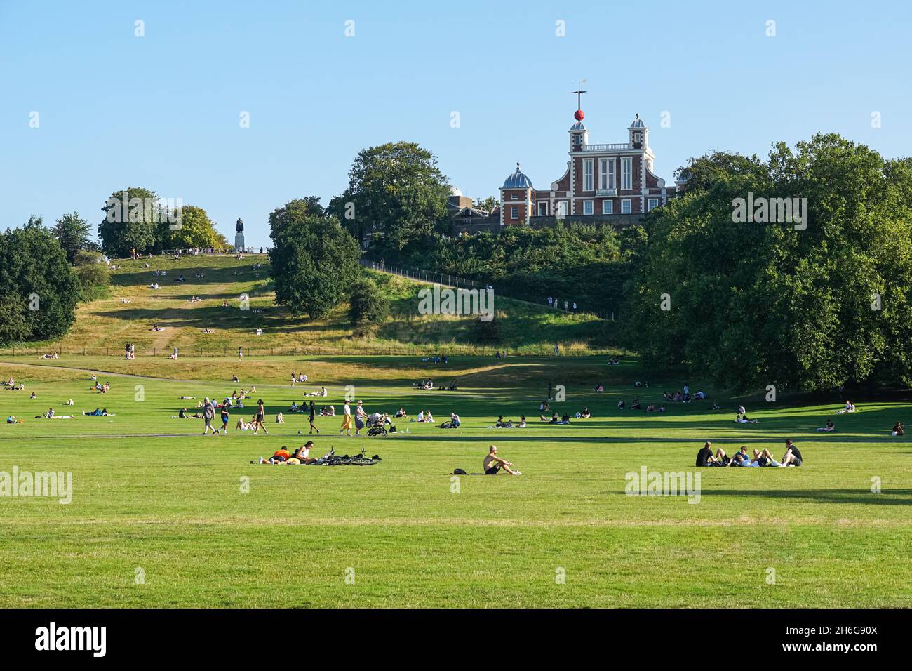 Menschen, die einen sonnigen Tag im Greenwich Park mit dem Royal Observatory im Hintergrund genießen, London, England, Großbritannien Stockfoto