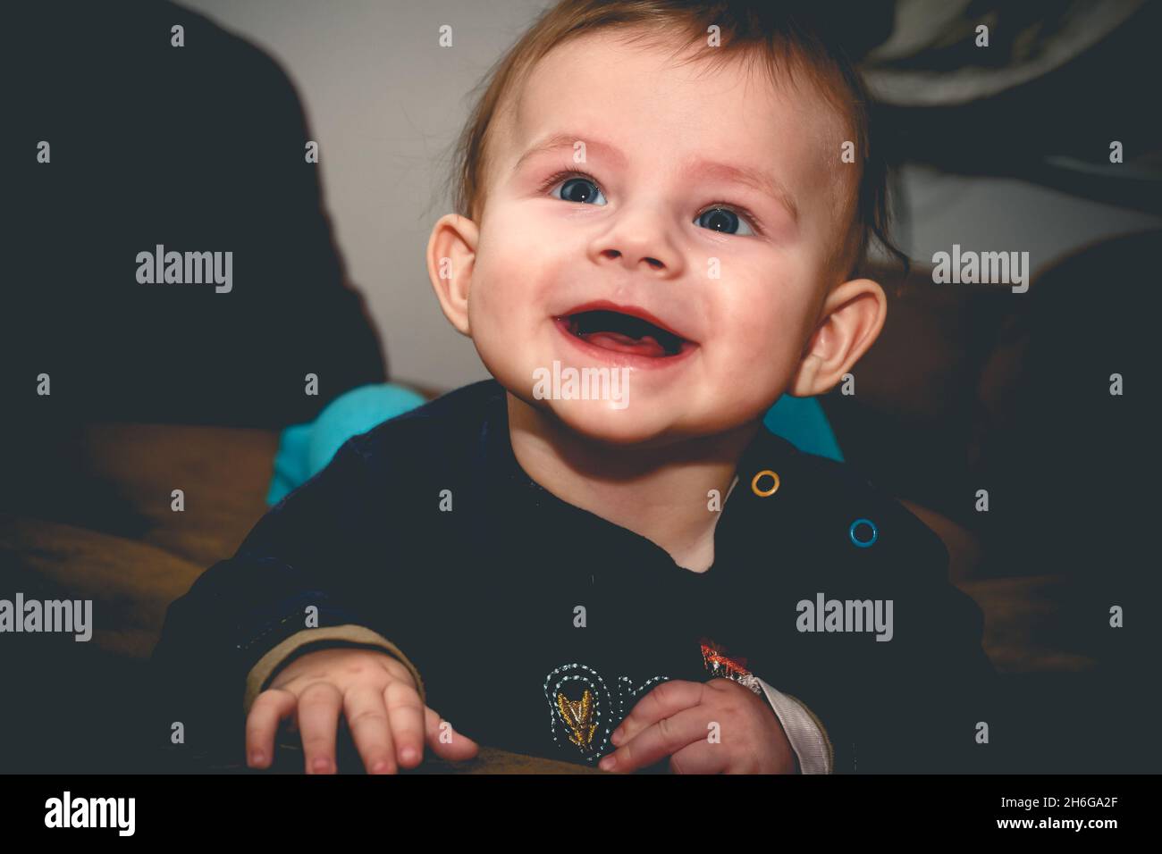 Fünf Monate alter Junge lag auf dem Bauch und lächelt weit Stockfoto