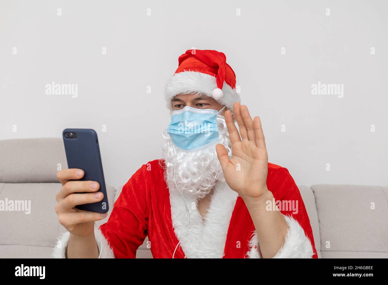 Als Weihnachtsmann gekleidet, der über eine Videokonferenz spricht Stockfoto