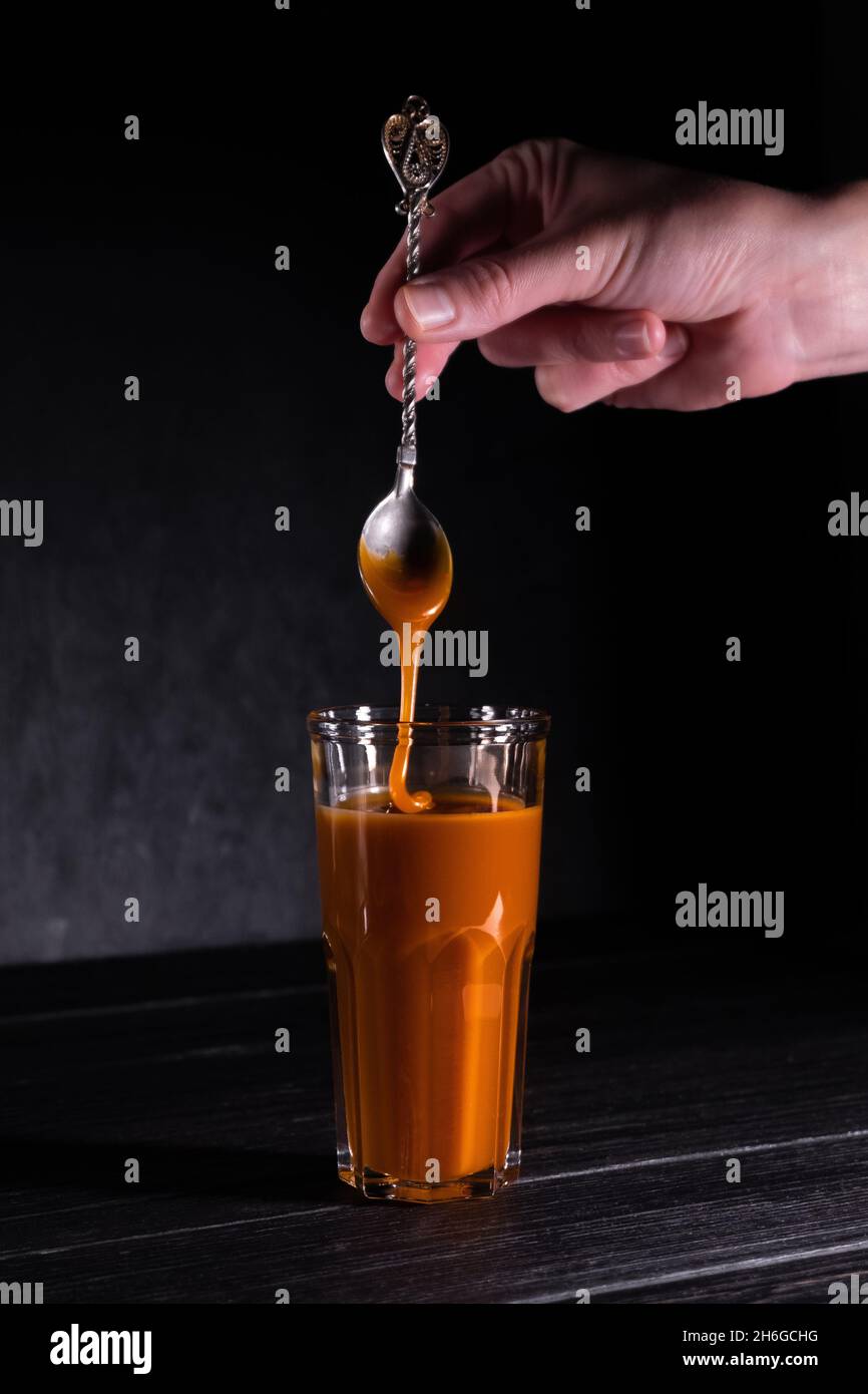 Hausgemachte gesalzene Karamellsauce in einem Glas auf dunklem Hintergrund. Text kopieren Stockfoto
