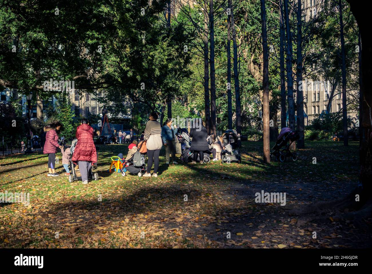 Am Montag, den 1. November 2021, treffen sich Nannie und Kinder unter den Bäumen von Maya Lins „Ghost Forest“ auf dem Rasen im Madison Square Park in New York. Die Ausstellung endet am 14. November und der Park wird mit der Deinstallation beginnen. (© Richard B. Levine) Stockfoto