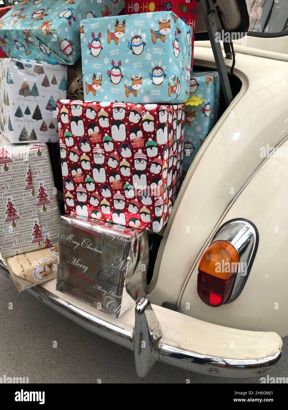 Ein Kofferraum voller Weihnachtsgeschenke in farbenfrohem Geschenkpapier, bereit zur Lieferung Stockfoto