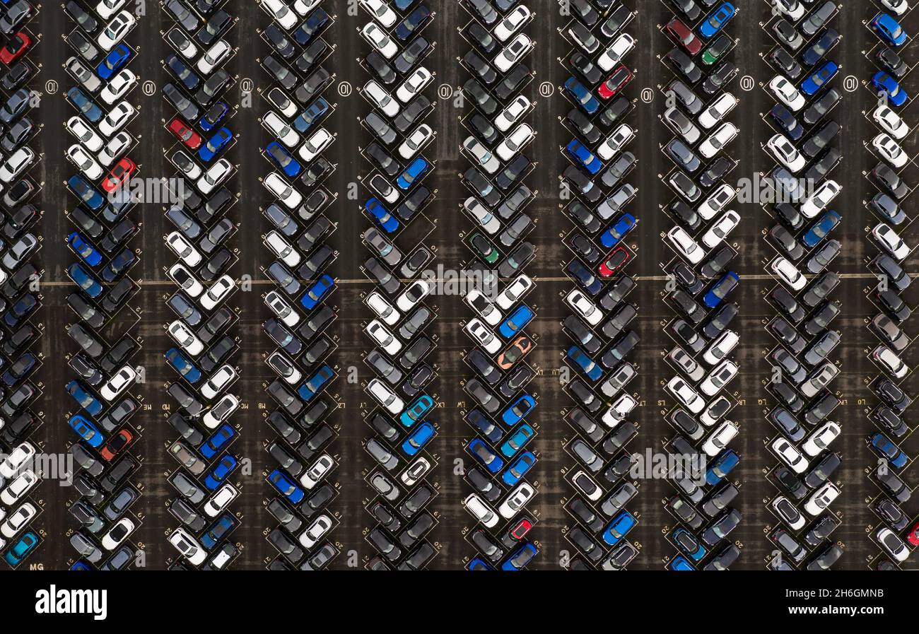 Eine Luftaufnahme direkt über dem Vorrat eines neuen Automobilherstellers an Fahrzeugen, die für den Export und Import bereit sind Stockfoto