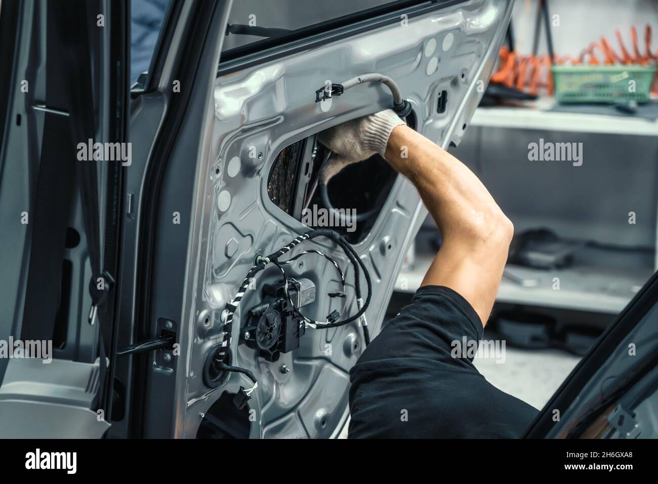 Auto-Service-Mitarbeiter demontiert Autotür für die Reparatur